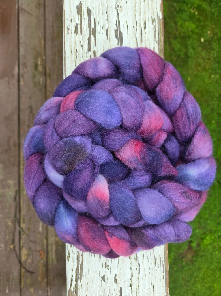 a braid of hand spinning fiber, in many shades of purple and pink 